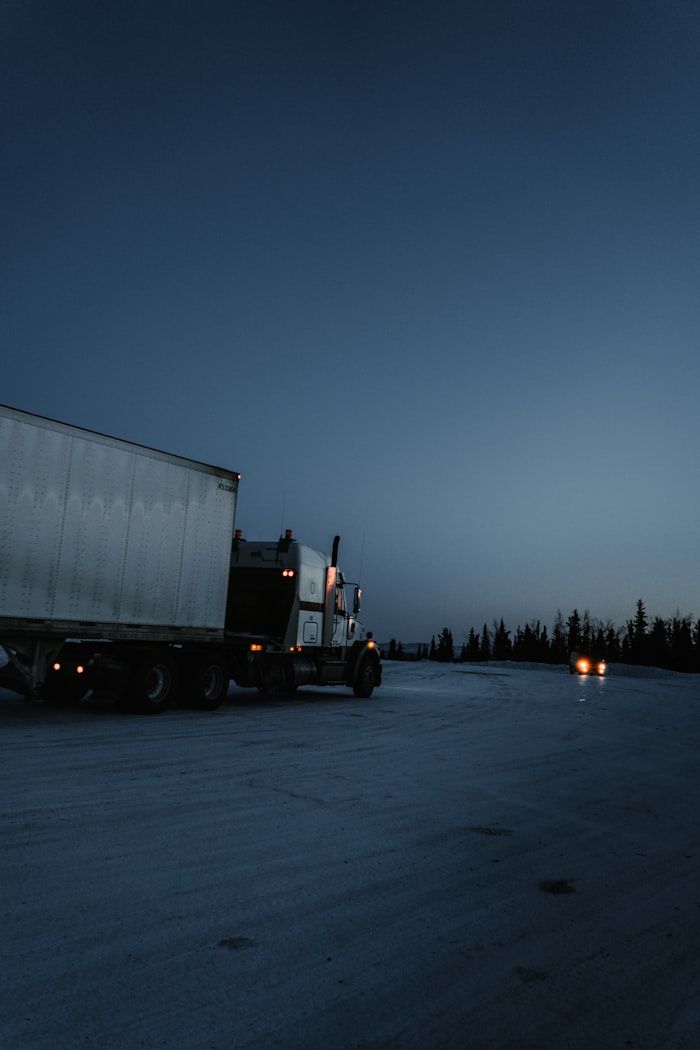 Semi truck idling with its marker lights on before dawn